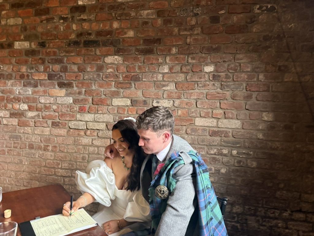 Katie and Adam signing the marriage schedule together at The Engine Works, Maryhill