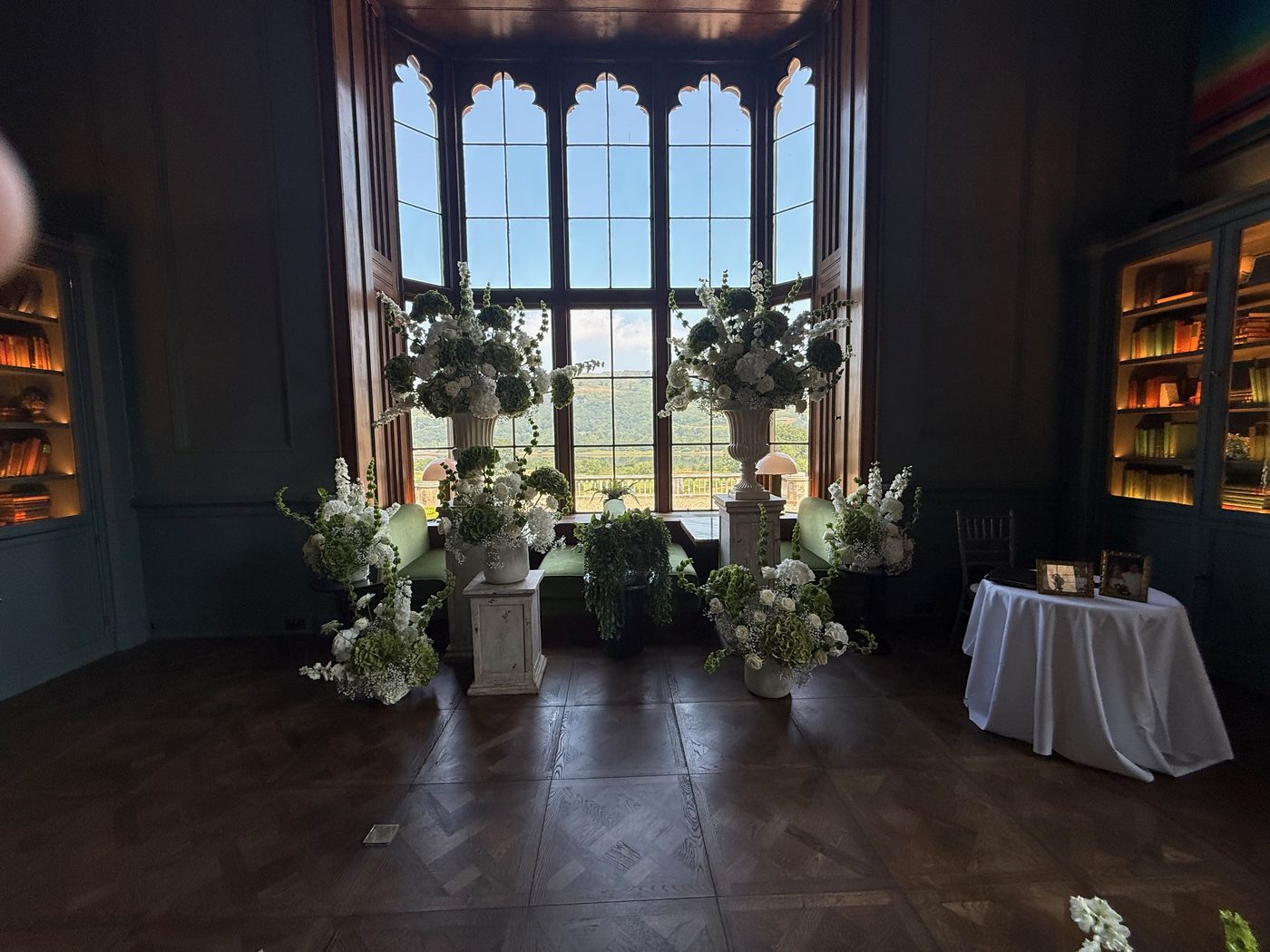 Celebrant John Paul Fitzpatrick with a newly married couple in Mar Hall's elegant library room, backlit bookcases behind them