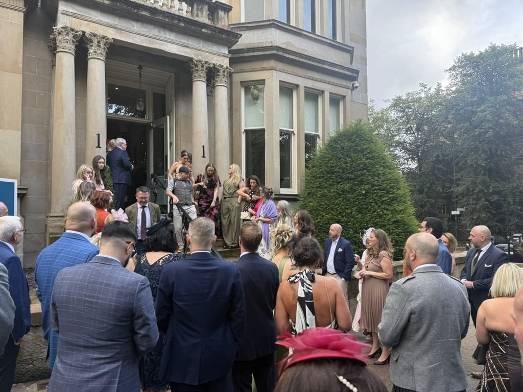 Wedding guests gathered on the steps and pavement outside the columned sandstone entrance of One Devonshire Gardens in Glasgow's West End