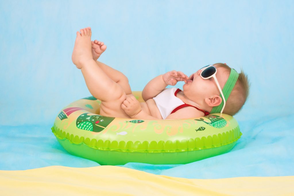 baby looking happy in a pool